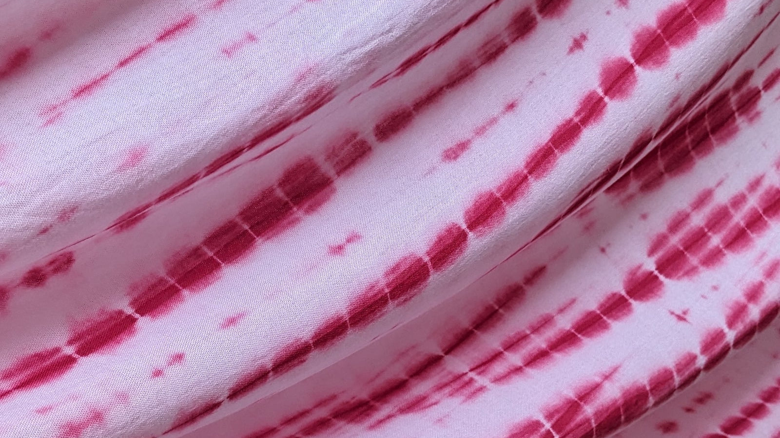 Close-up of pink and white patterned hand dyed tie-dye rayon fabric