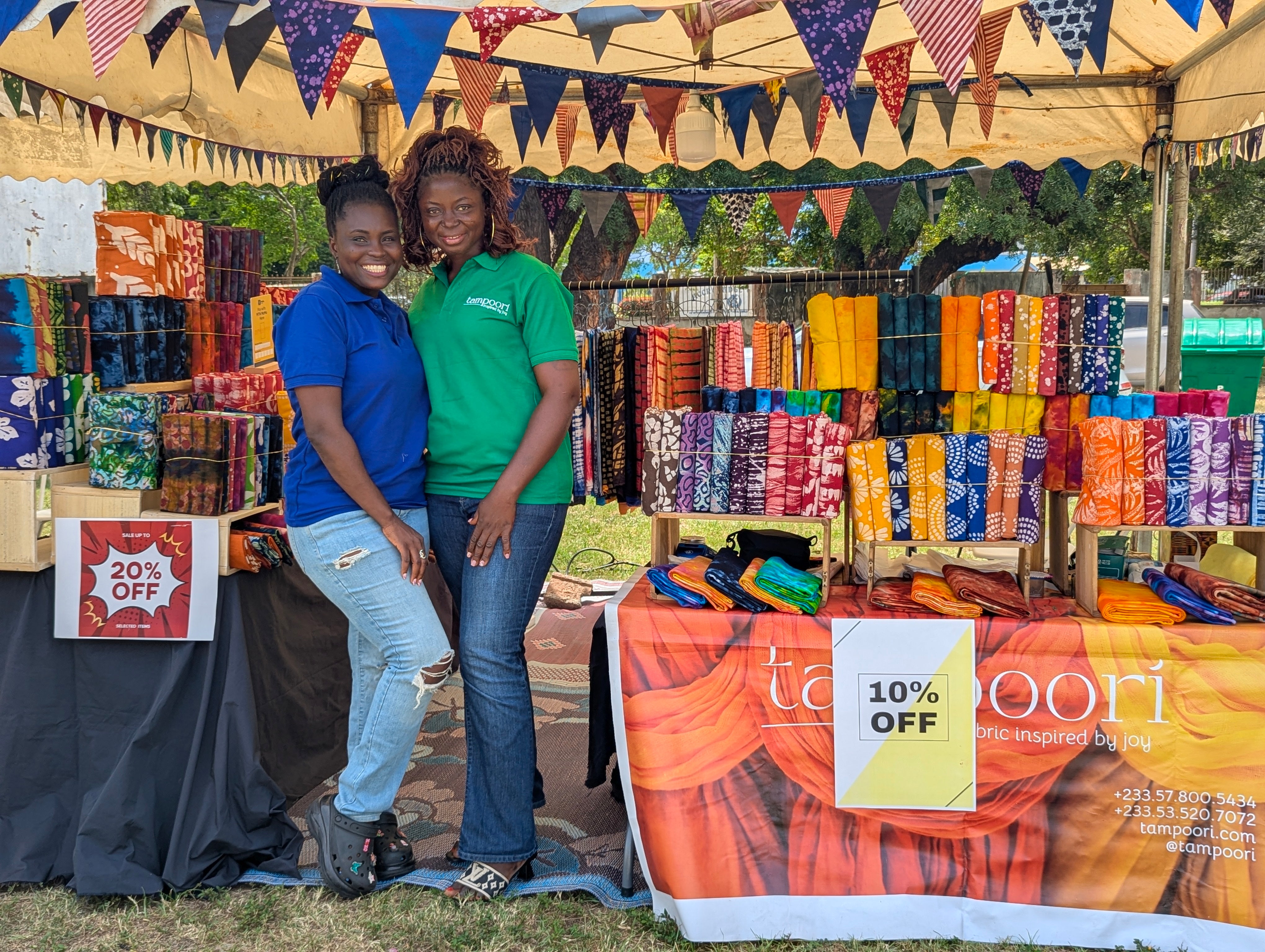 Two African women artisans at Tampoori smixing dyes and examining batik patterns sustainable textile production in Ghana.