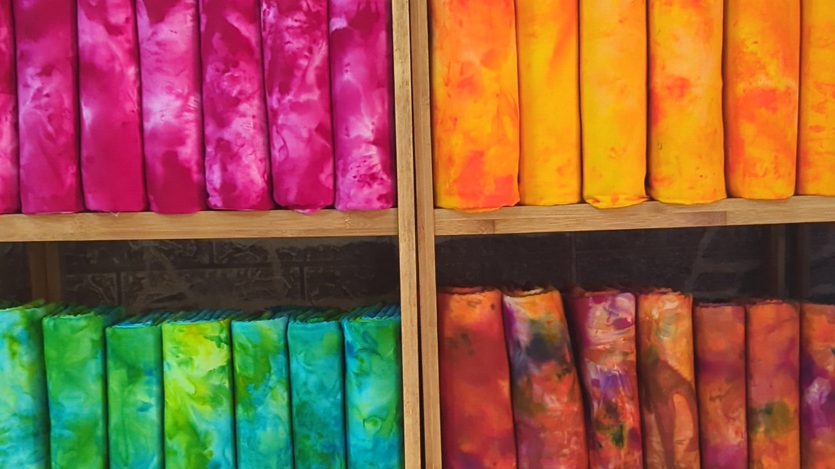 Hand-dyed batik and tie-dye fabrics by Tampoori displayed in a modern retail store - sustainable African textiles made in Ghana for stockists and designers.