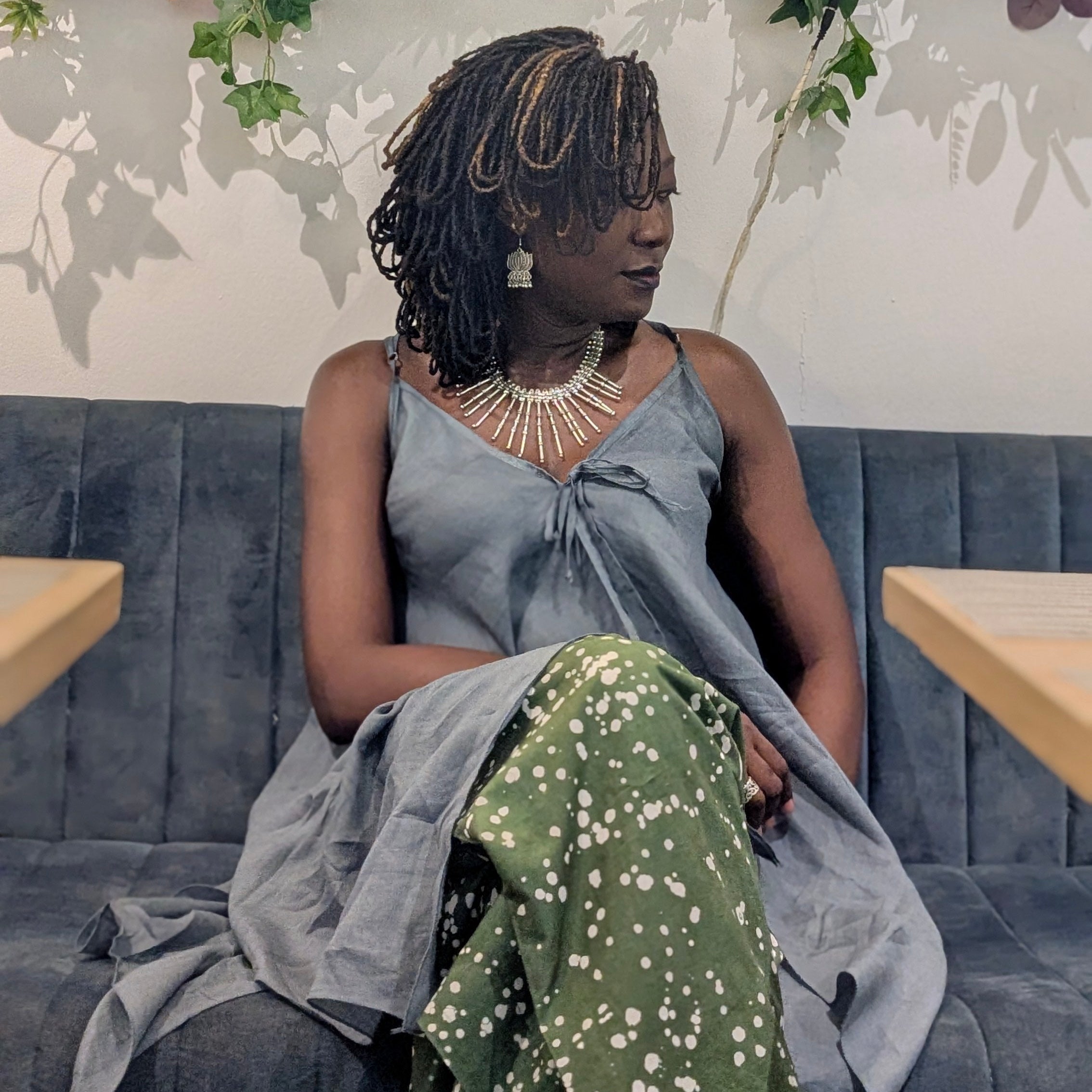 Woman sitting in a cafe with floral decorations and 'Lola's Bistro' sign.